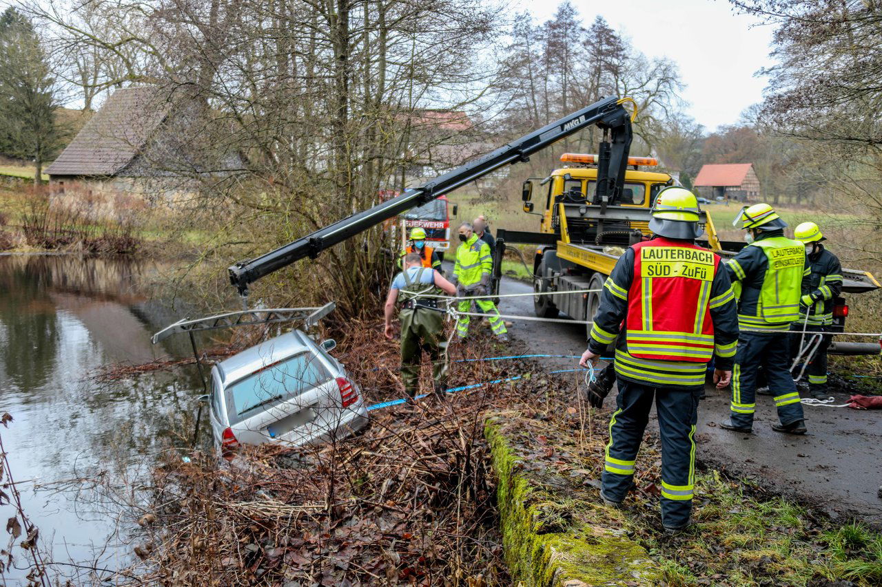 Mercedes fährt bei Schloss Eisenbach in Teich Fahrzeuginsassen