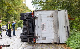 Mit Post beladener Lkw kippt um - Fahrer unverletzt, aber Vollsperrung