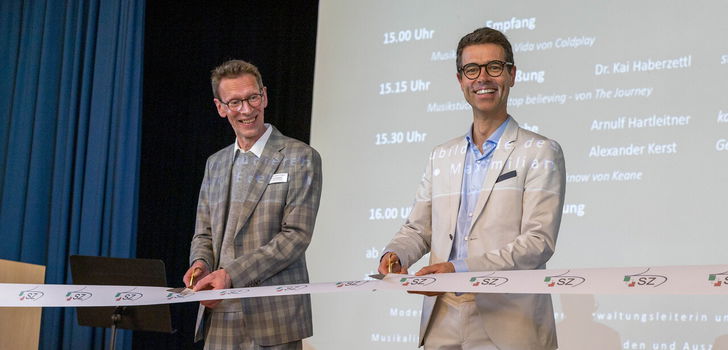 Arnulf Hartleitner, der kaufmännische Direktor des HKZ und Dr. Kai Haberzettl, stellvertretender Direktor des Studienzentrums schneiden zur Eröffnung das Band durch.