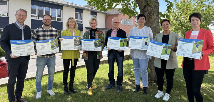 Landrat Dr. Jens Mischak und Bewegungskoordinator Dominic Günther übergeben Christiane Enders-Pfeil Familienzentrum Homberg), Gudrun Haas, Hans-Dieter Herget (Mehrgenerationenhaus Schotten), Sandra Böttner, Anja Schwalm (Mehrgenerationenhaus Romrod) und Hombergs Bürgermeisterin Simke Ried (von links) die ATP-Schilder, die mehr Bewegung in die Kommunen bringen sollen