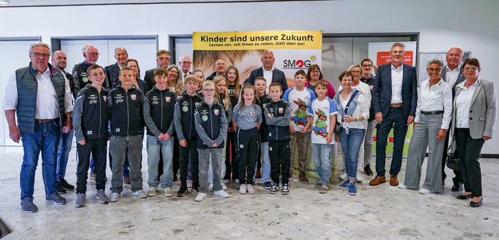 Innenminister Roman Poseck u. a. mit dem 1. Vorsitzenden des Vereins SMOG Erwin Maisch, weiteren Vereinsmitgliedern und Schülerinnen und Schülern.