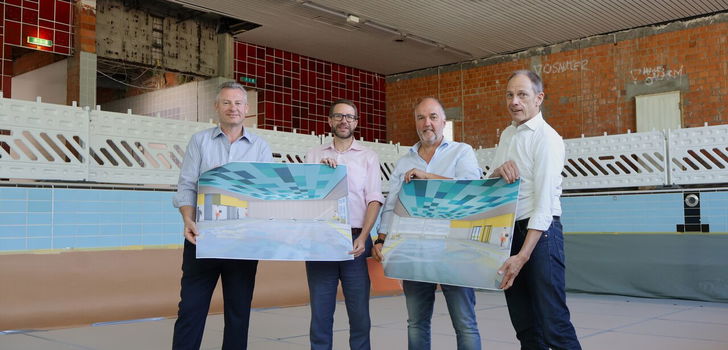 Erster Kreisbeigeordneter Andreas Hofmann, Landrat Thorsten Stolz, Betriebsleiter Reinhold Walz und Architekt Gösta Weber zeigen die Pläne, wie das Hallenbad künftig aussehen wird.